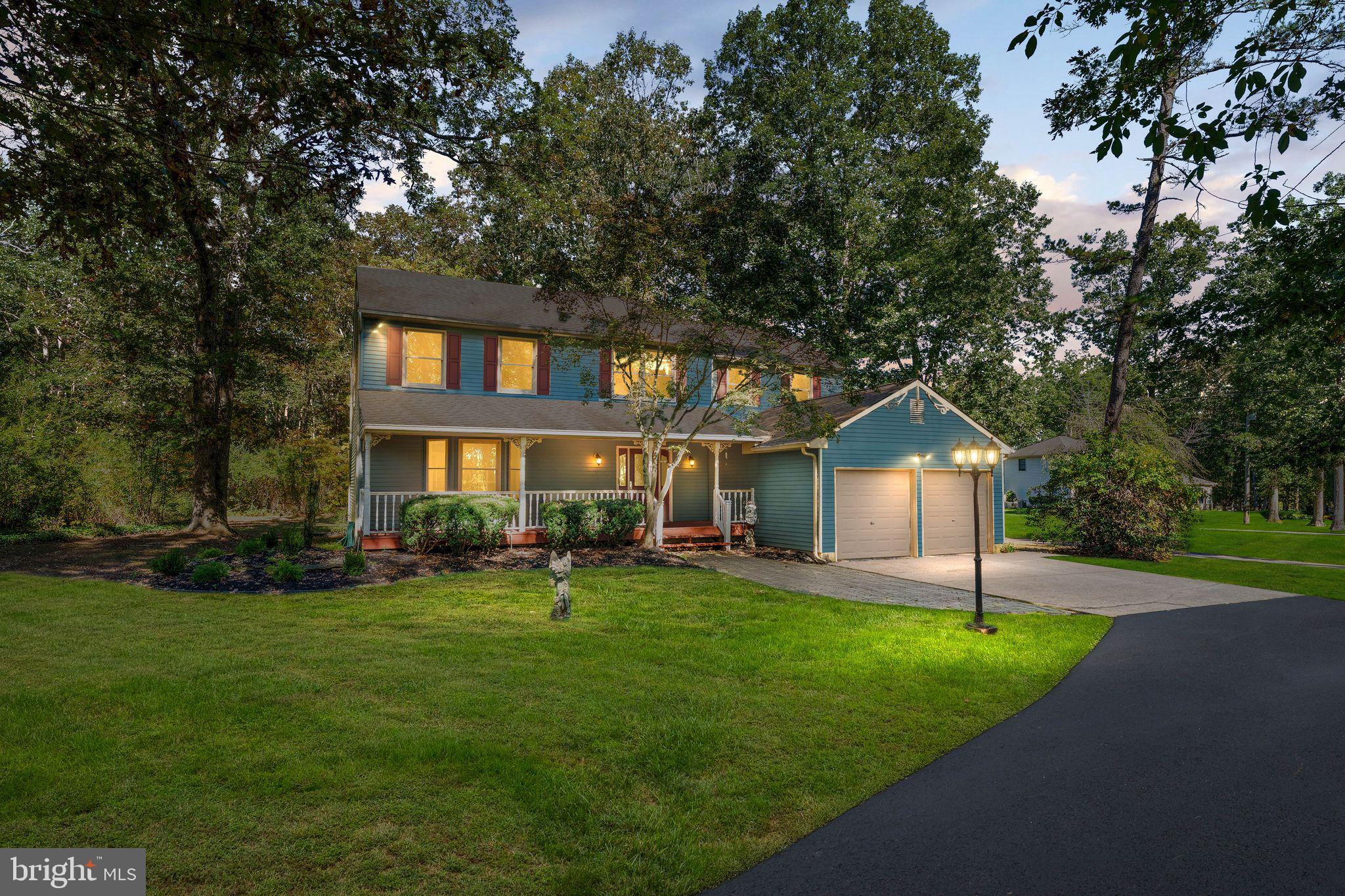 a front view of a house with a yard and trees