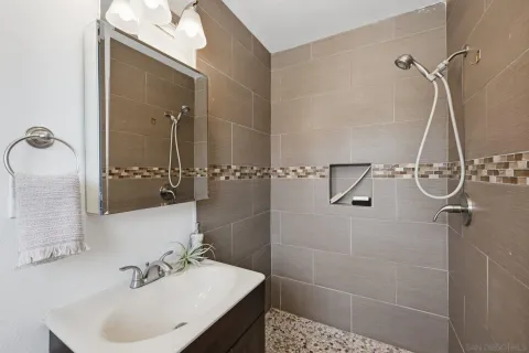 a bathroom with a sink shower and a mirror