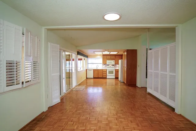 a view of a hallway with wooden floor and a cabinet