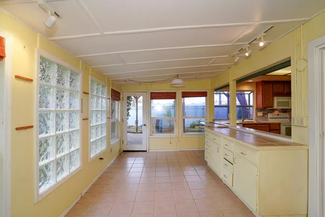 a large kitchen with stainless steel appliances a large counter top a stove and a refrigerator