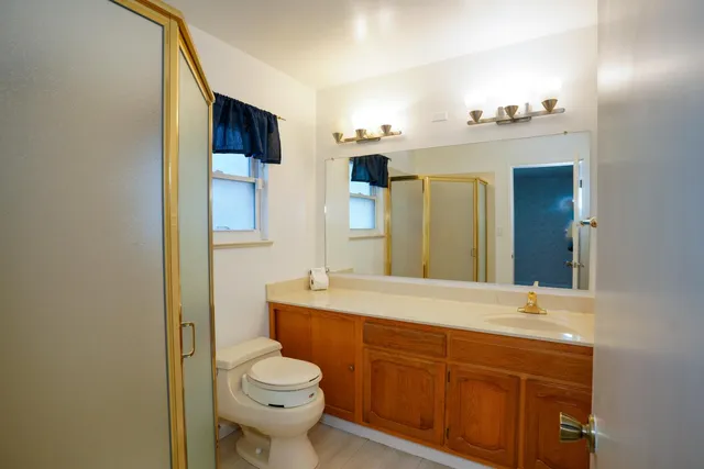 a bathroom with a sink a toilet and shower