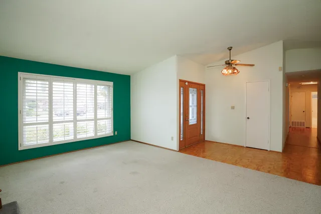an empty room with fan and windows