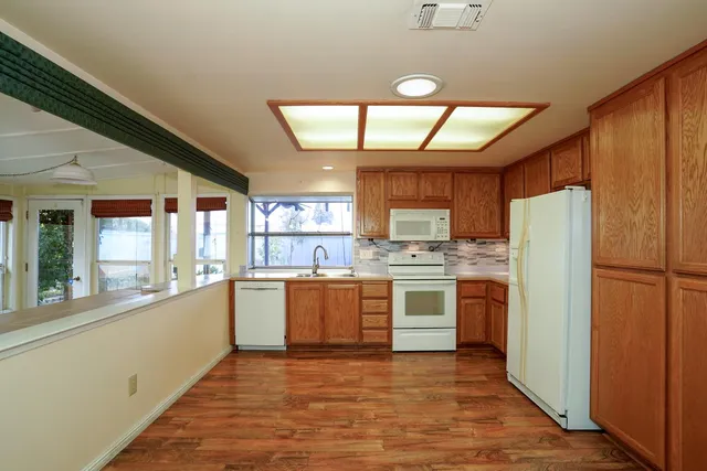 a kitchen with stainless steel appliances granite countertop a refrigerator and a stove top oven