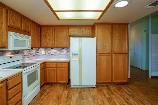 a kitchen with a refrigerator sink and cabinets