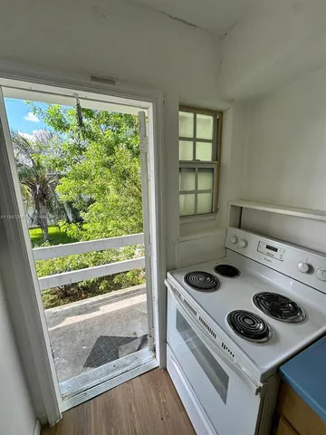 a white stove top oven sitting next to a window