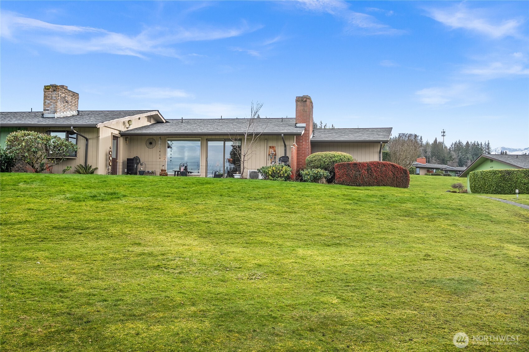 1301 South 3rd Avenue, Unit 15D Sequim, WA 98382 - Photo 19 of 26 a big white house with a big yard and large trees
