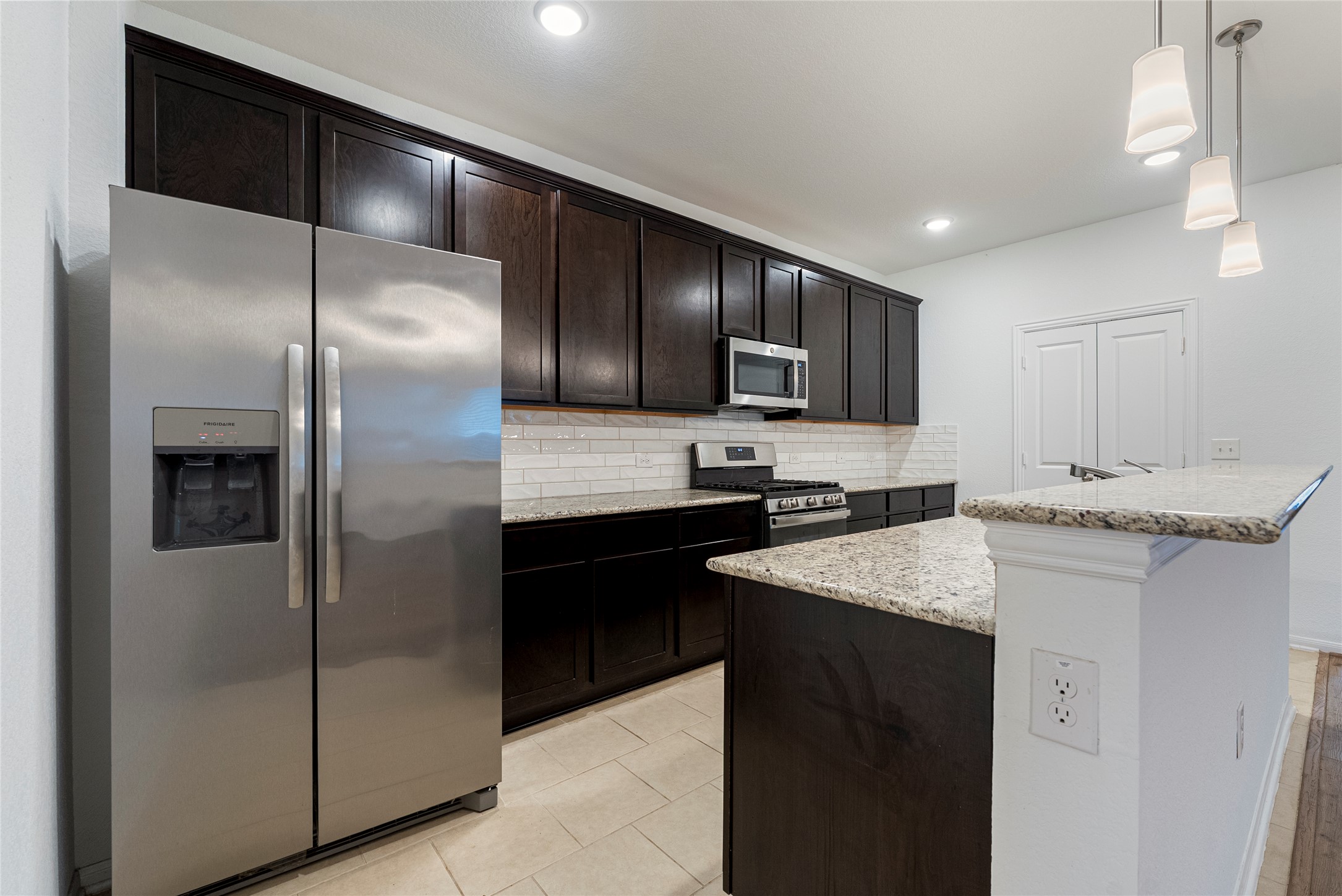 149 Biscayne Drive Kyle, TX 78640 - Photo 6 of 20 a kitchen with stainless steel appliances granite countertop a sink and a refrigerator