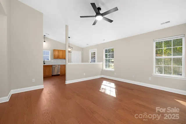 a view of a livingroom with wooden floor and a ceiling fan
