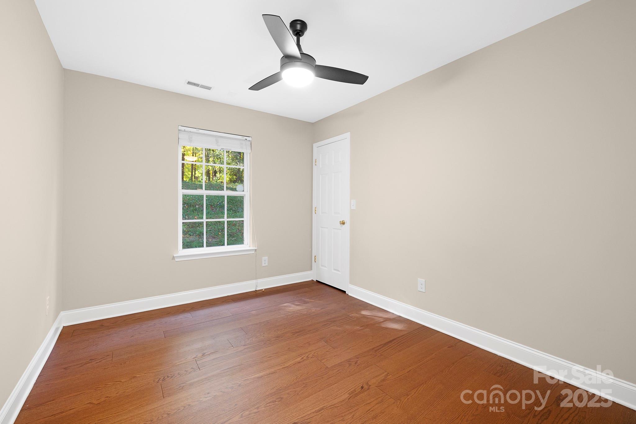 2012 Pheasant Glen Road Charlotte, NC 28214 - Photo 8 of 20 an empty room with wooden floor and windows