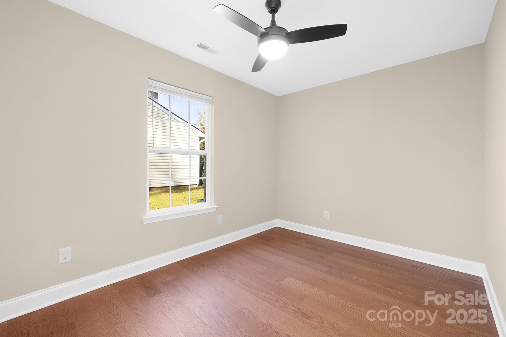 2012 Pheasant Glen Road Charlotte, NC 28214 - Photo 9 of 20 an empty room with a window and a ceiling fan