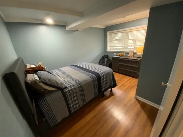 a bed sitting in a bedroom next to a window