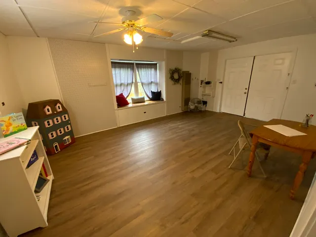a view of a room with gym equipment and wooden floor
