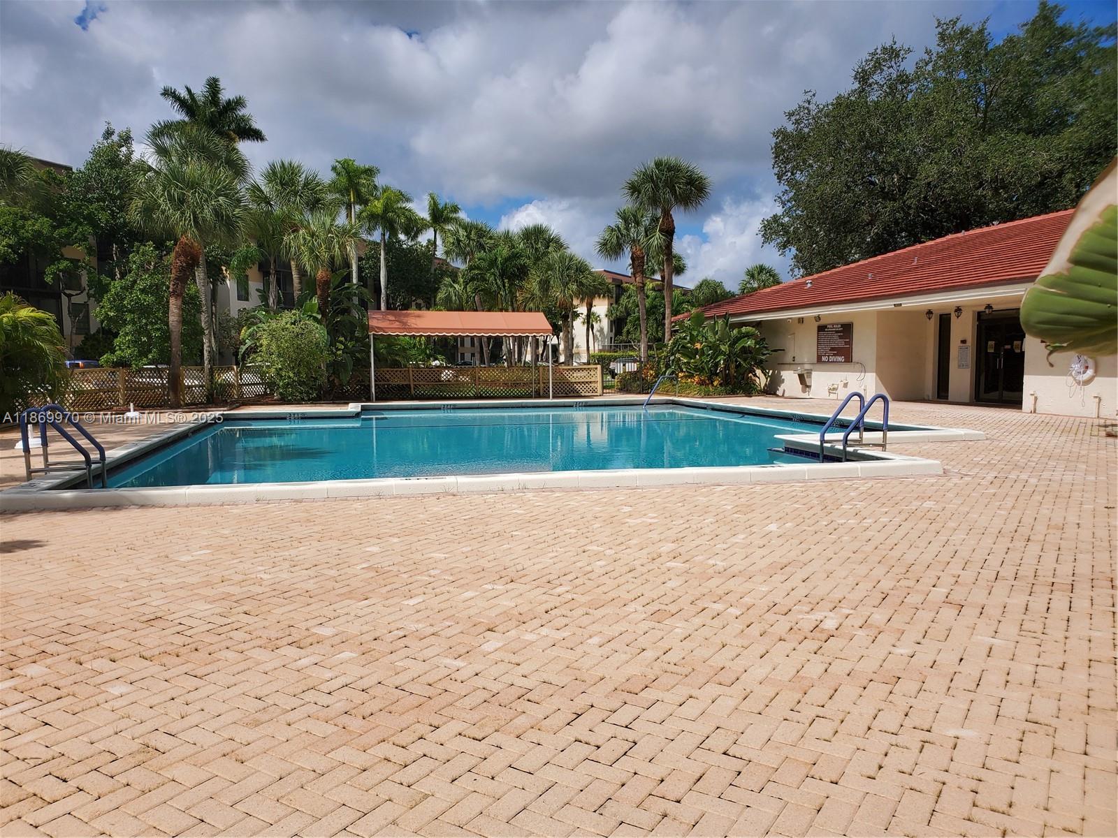 5550 Northwest 44th Street, Unit 111B Lauderhill, FL 33319 - Photo 20 of 22 a swimming pool with outdoor seating and yard