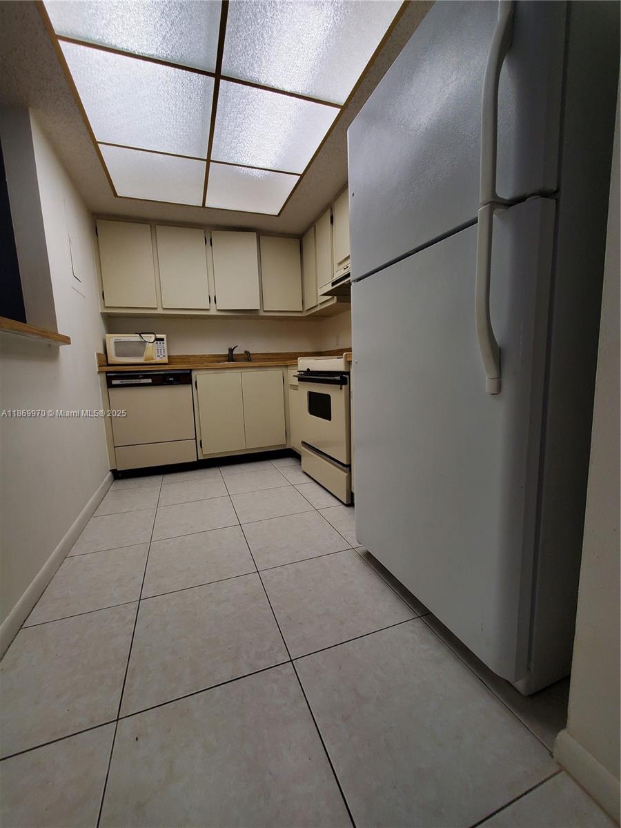 5550 Northwest 44th Street, Unit 111B Lauderhill, FL 33319 - Photo 9 of 22 a kitchen with stainless steel appliances granite countertop a sink a stove a refrigerator and cabinets