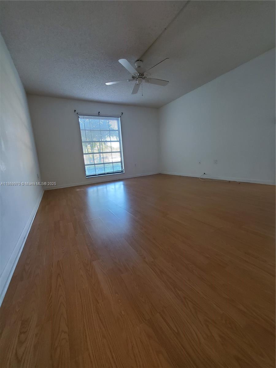 5550 Northwest 44th Street, Unit 111B Lauderhill, FL 33319 - Photo 10 of 22 an empty room with wooden floor and windows