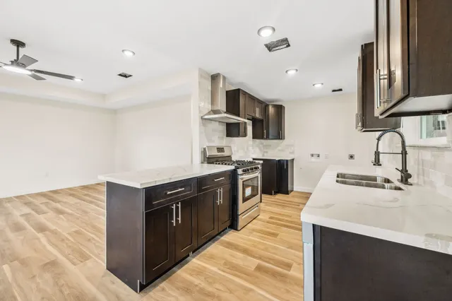 a kitchen with stainless steel appliances granite countertop a sink stove and refrigerator