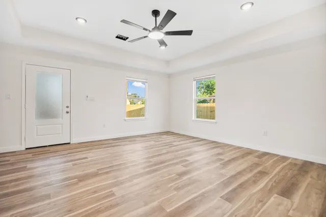 an empty room with window and ceiling fan