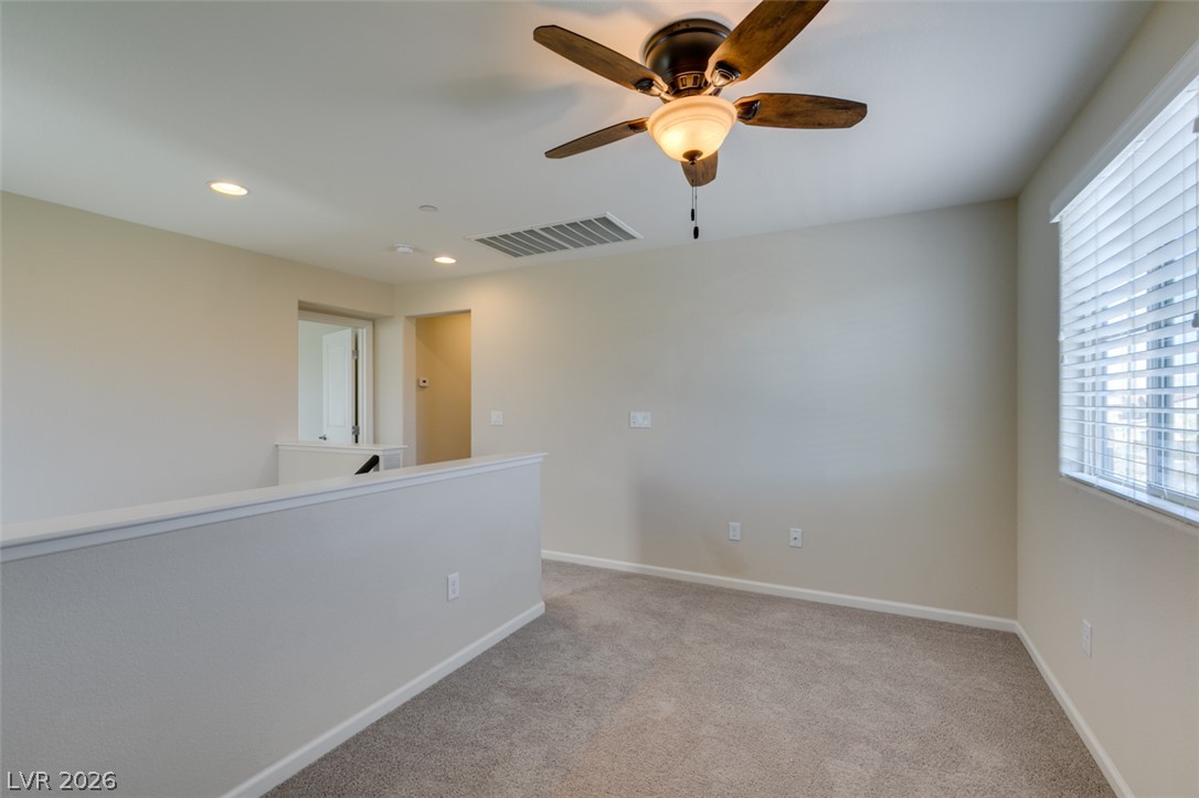 2549 Sable Ridge Street Henderson, NV 89044 - Photo 36 of 48 A versatile upstairs loft with carpeted flooring and a modern ceiling fan, ideal for various uses.