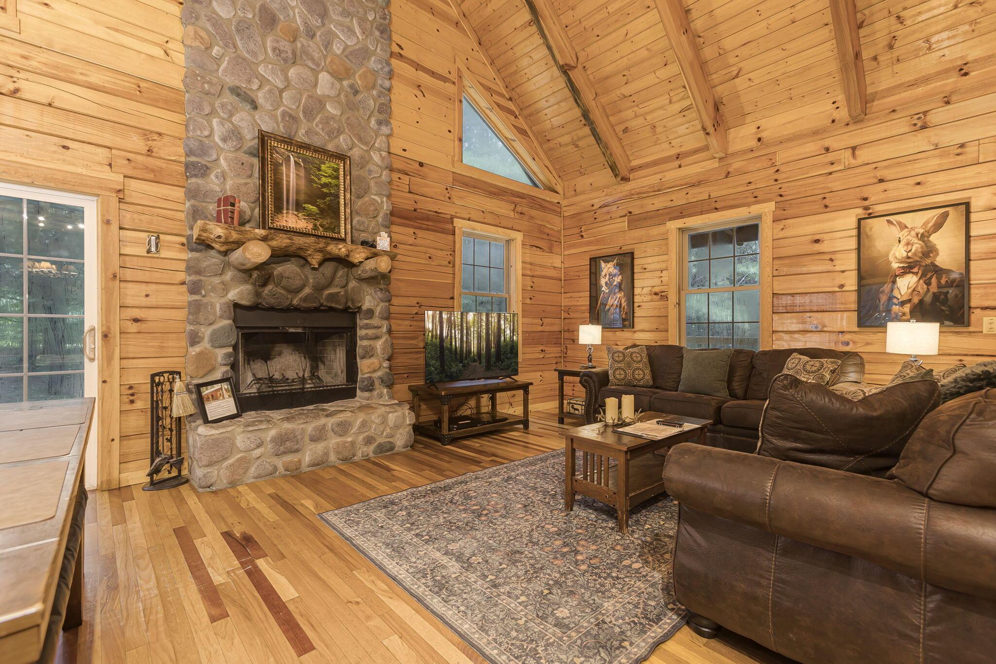 19475 Linden Road Logan, OH 43138 - Photo 10 of 94 Vaulted ceiling with exposed wood beams, featuring a floor-to-ceiling stone fireplace with a natural wood mantel
