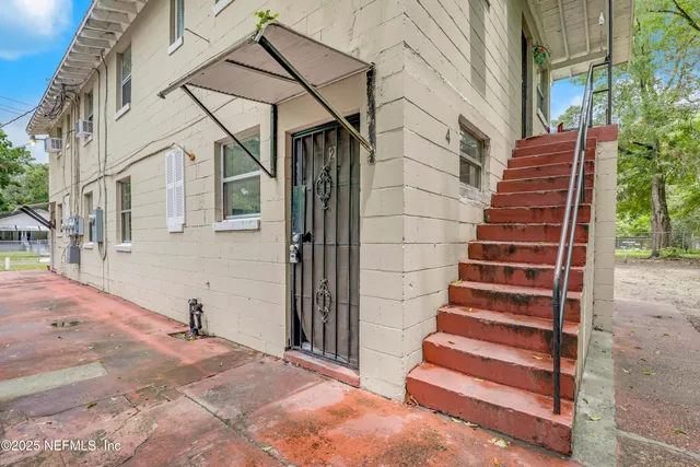 a view of a house with a yard and stairs
