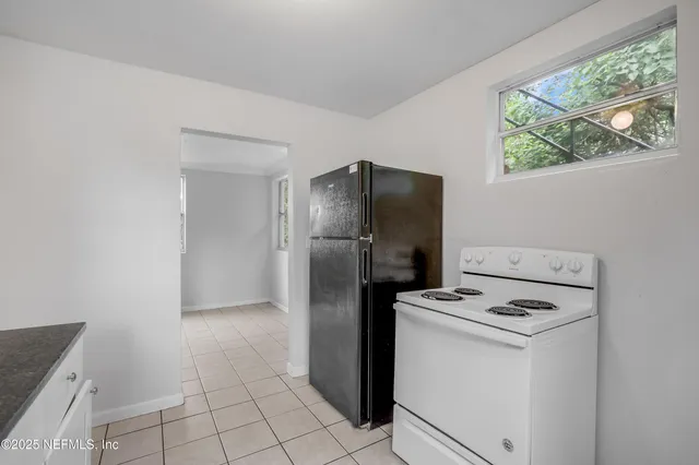 a kitchen with a refrigerator sink stove and cabinets