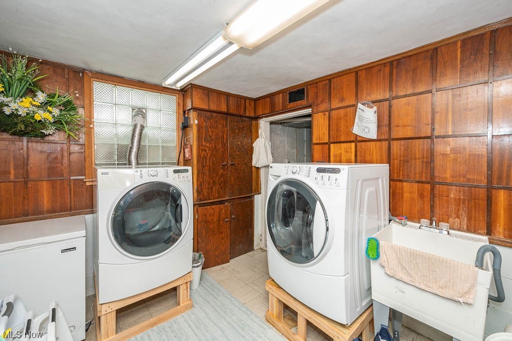 807 North Road Southeast Warren, OH 44484 - Photo 20 of 24 Laundry area featuring washer and dryer, wood walls, sink, and light tile floors