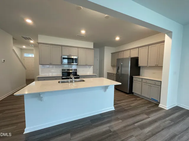 a view of kitchen with refrigerator stove microwave and cabinets