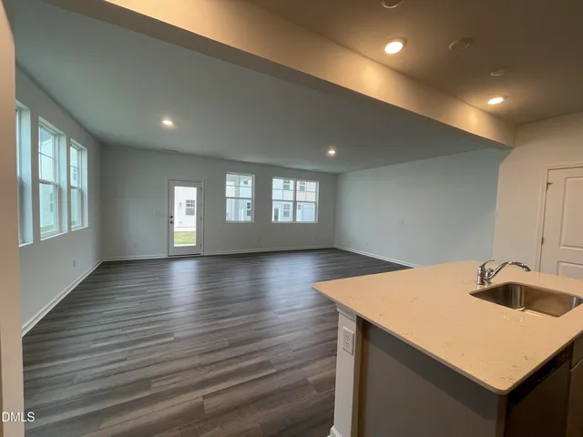 a kitchen with a sink and dishwasher with wooden floor