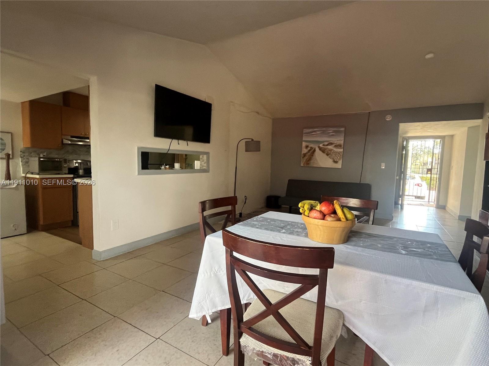 12215 Southwest 119th Terrace Miami, FL 33186 - Photo 4 of 17 a living room with furniture and a flat screen tv