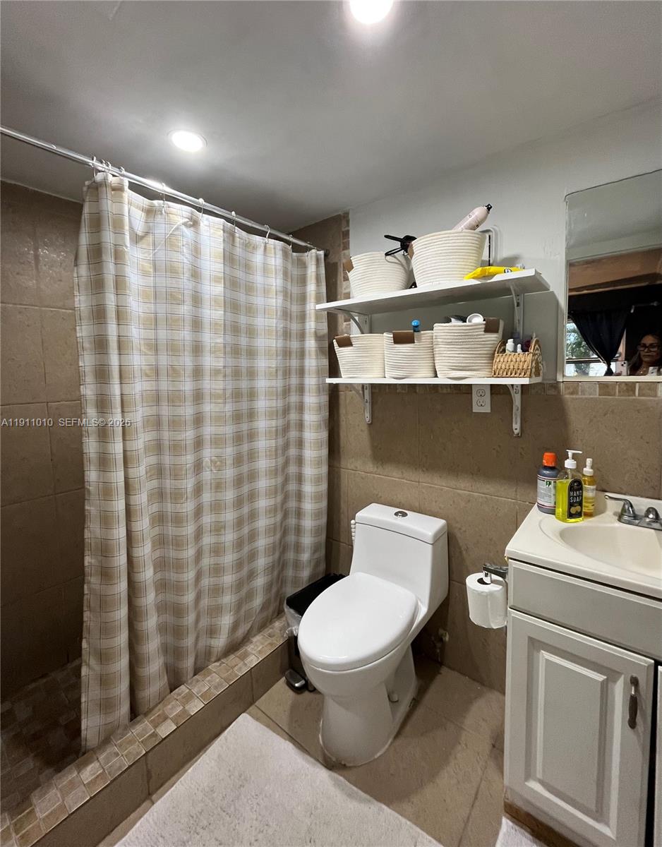 12215 Southwest 119th Terrace Miami, FL 33186 - Photo 9 of 17 a white toilet sitting next to a bathroom sink and vanity
