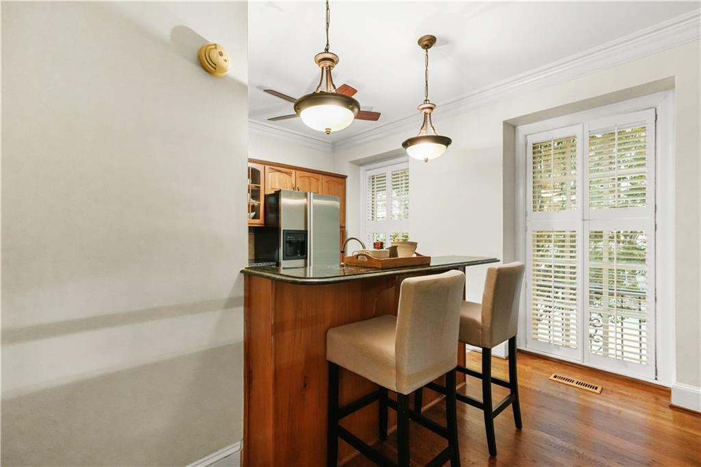 30 5th Street Northeast, Unit 101 Atlanta, GA 30308 - Photo 4 of 25 a dining room with wooden floor a chandelier a wooden table and chairs
