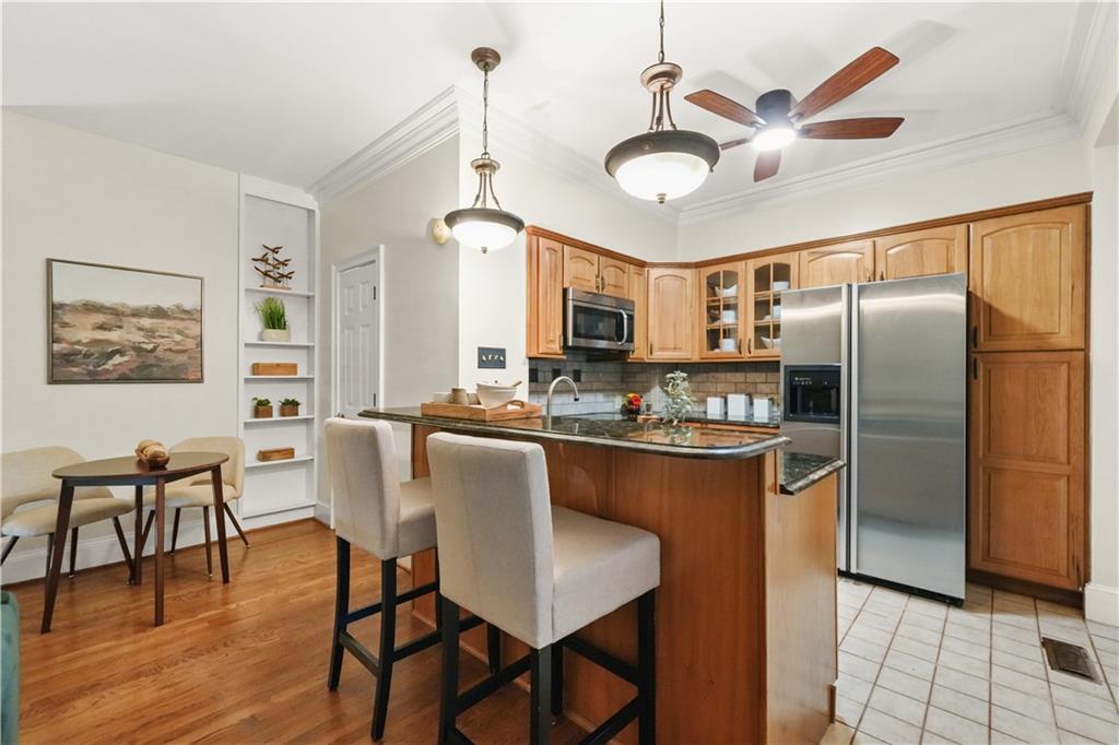 30 5th Street Northeast, Unit 101 Atlanta, GA 30308 - Photo 5 of 25 a kitchen with stainless steel appliances granite countertop a dining table chairs refrigerator and cabinets