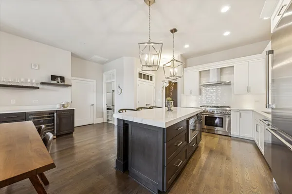 a kitchen with stainless steel appliances granite countertop a sink a stove and a refrigerator