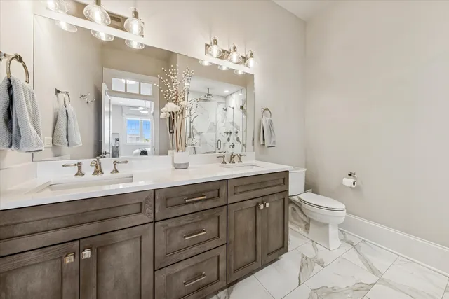 a bathroom with a double vanity sink mirror and toilet