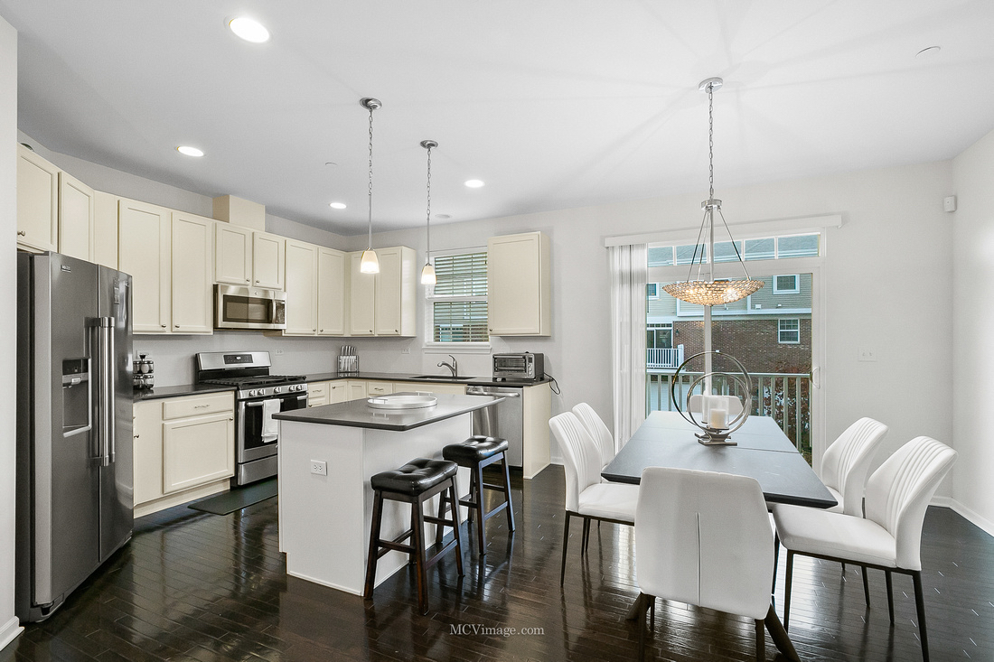 2967 Madison Drive Naperville, IL 60564 - Photo 6 of 24 a kitchen with stainless steel appliances kitchen island granite countertop a dining table chairs refrigerator and microwave