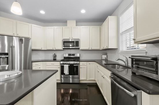 2967 Madison Drive Naperville, IL 60564 - Photo 7 of 24 a kitchen with stainless steel appliances white cabinets sink a stove a microwave and a refrigerator