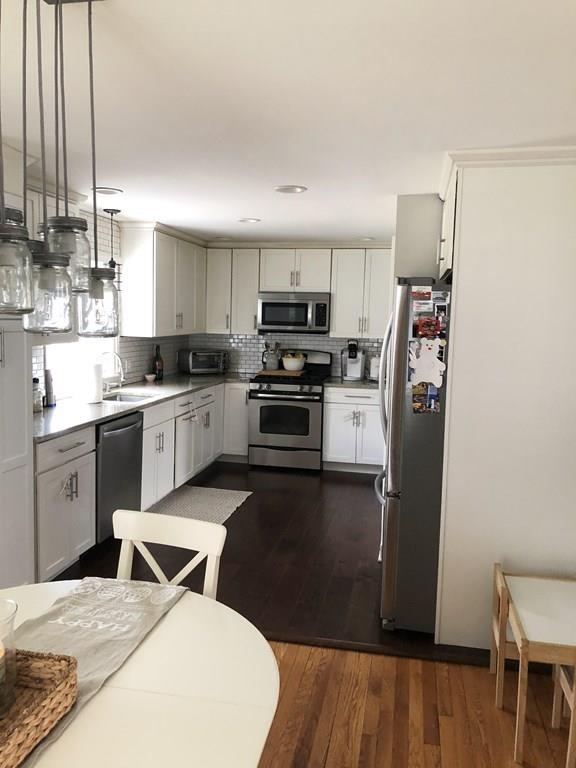 16 Mayfield Street Springfield, MA 01108 - Photo 2 of 20 a kitchen with stainless steel appliances granite countertop a refrigerator a stove top oven a sink dishwasher and white cabinets with wooden floor