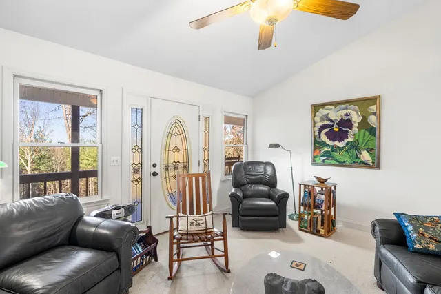 a living room with furniture ceiling fan and a window