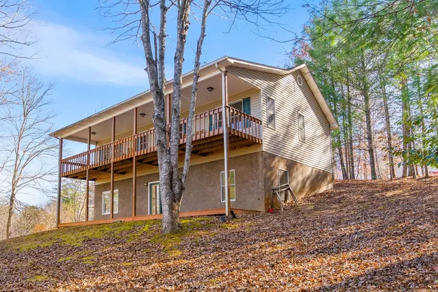 a view of a house with a yard and large trees