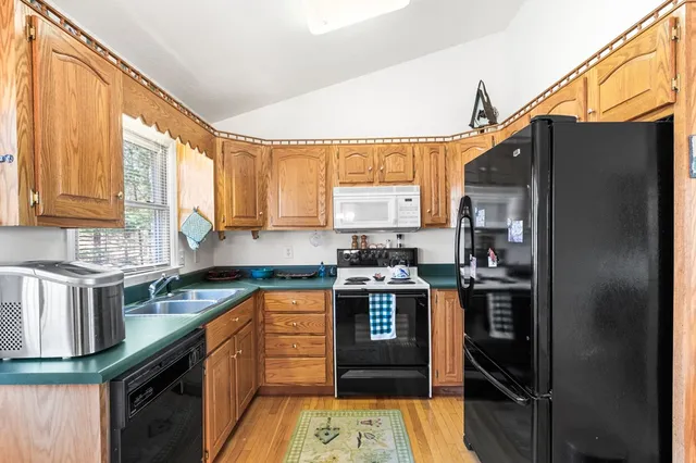 a kitchen with stainless steel appliances granite countertop a stove a sink and a refrigerator