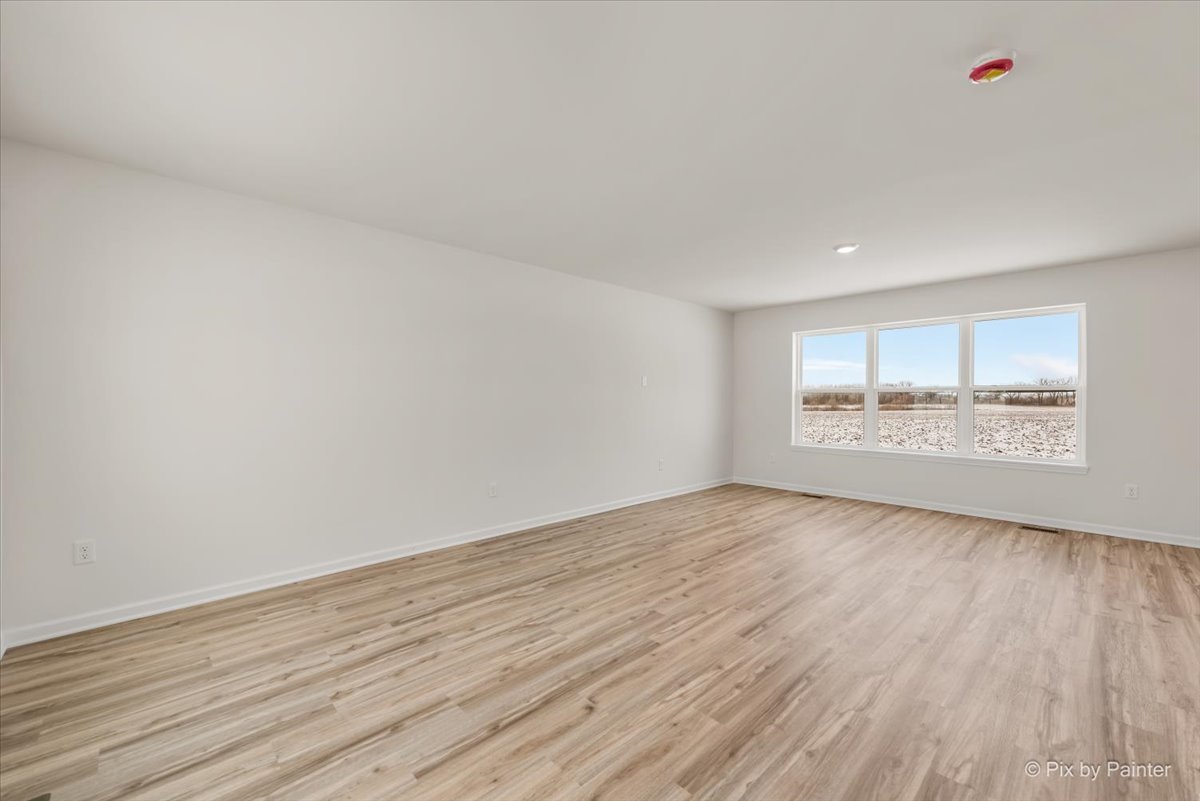 611 Apple Valley Road Harvard, IL 60033 - Photo 12 of 29 an empty room with wooden floor and windows