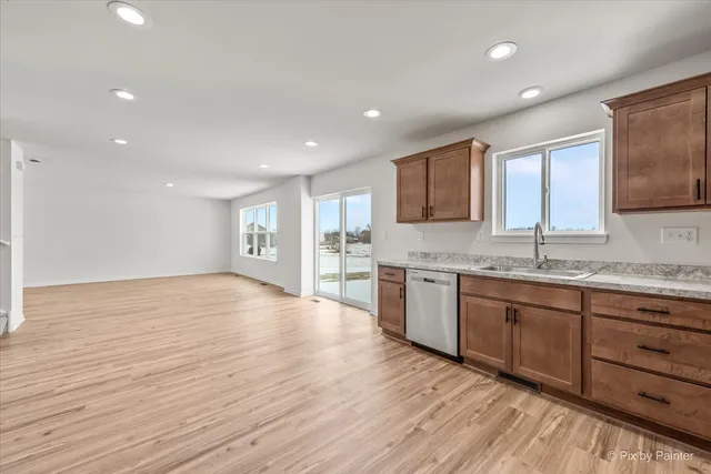 a large kitchen with granite countertop wooden cabinets a sink and dishwasher