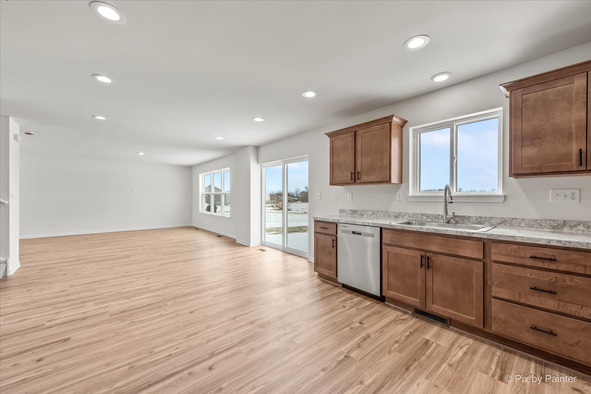 611 Apple Valley Road Harvard, IL 60033 - Photo 6 of 29 a large kitchen with granite countertop wooden cabinets a sink and dishwasher