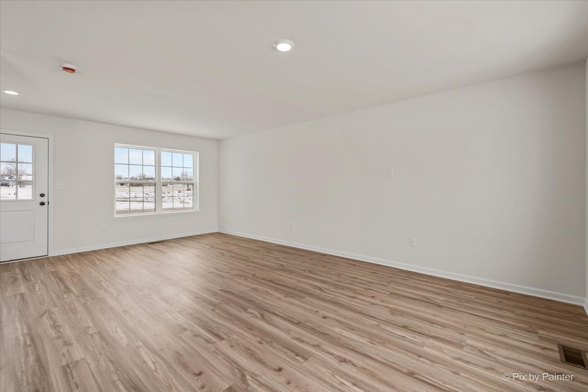 611 Apple Valley Road Harvard, IL 60033 - Photo 9 of 29 an empty room with wooden floor and windows