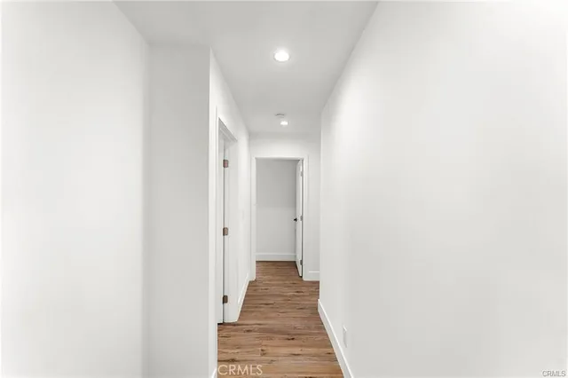 a view of a hallway with wooden floor