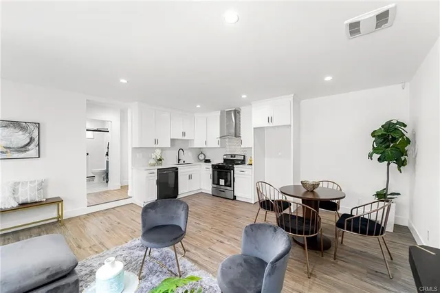a living room with furniture kitchen view and a potted plant