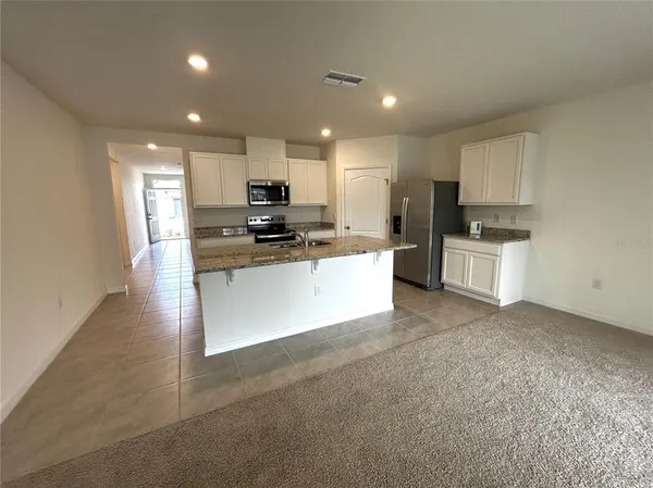 a large kitchen with cabinets and stainless steel appliances