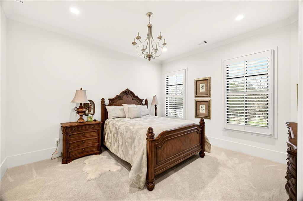 150 Fortress Way Jefferson, GA 30549 - Photo 60 of 83 a spacious bedroom with a bed and a chandelier