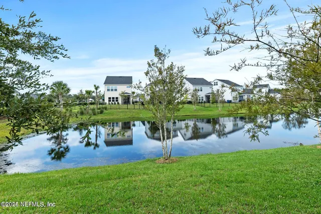 a view of a lake with a yard and a fountain