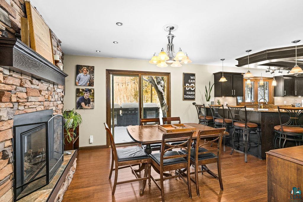421 St Louis River Road Proctor, MN 55810 - Photo 22 of 57 Dining area with dark wood-style floors, a fireplace, and suspended lighting